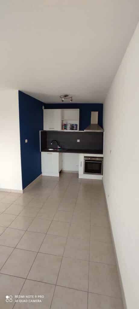 Cuisine moderne avec mur bleu marine et meubles blancs Kitchenette moderne avec mur bleu marine, meubles blancs et four encastré.