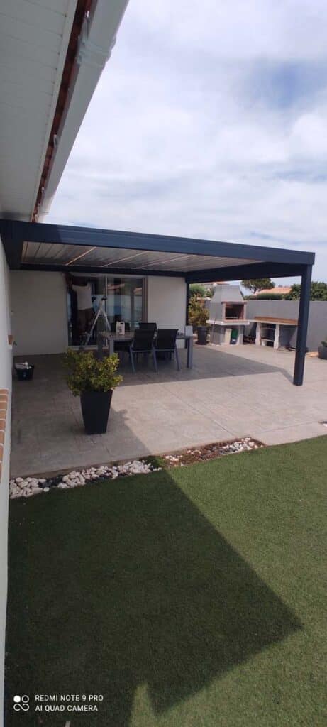Aménagement terrasse avec pergola bioclimatique moderne Pergola bioclimatique grise, terrasse, mobilier et barbecue. Redmi Note 9 Pro AI Quad Camera.